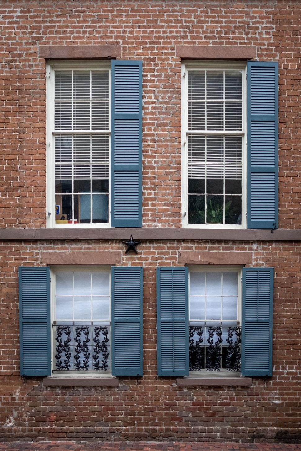 Fenêtre aux volets bleus, symbole d'une maison bien entretenue